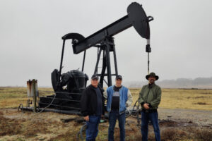 Nano Gas™ Environmental team members standing in front of an oil well