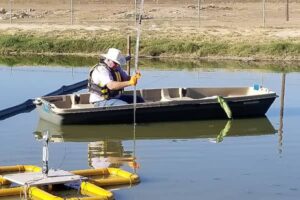 Man in a boat using rural wastewater treatment technologies