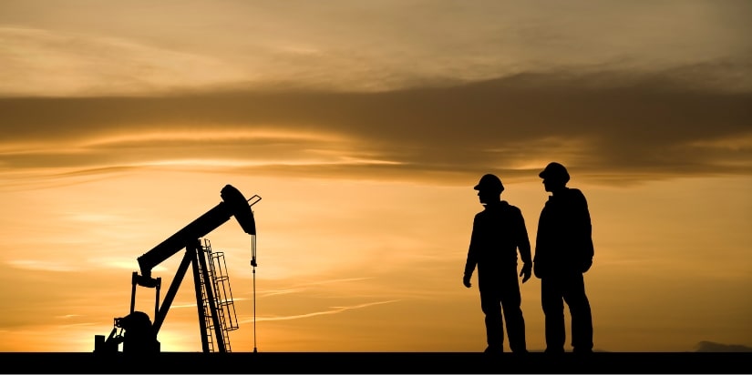 An oil rig and workers at sunset